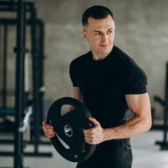Young sports man training at the gym